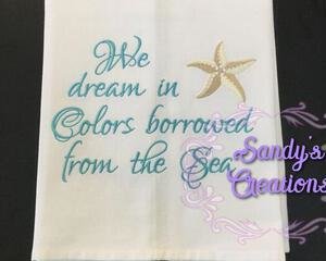 Tea Towel embroidered with a star fish with the saying, We dream in colors borrowed from the searoduct image